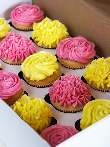 Deliciosos cupcakes em caixa de papelão com um chapéu na forma de uma rosa — Fotografia de Stock