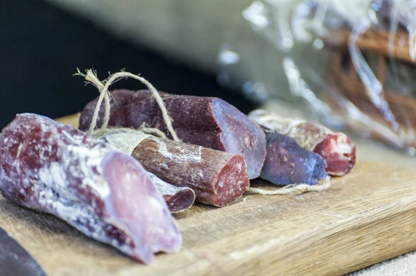 Salami / italian sausage in a food shop . Wooden cutting board with salami