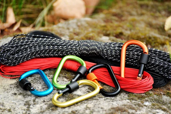 Metal carabine and rope for mountaineering. Photo of colored carabines and rope. Climbing concept