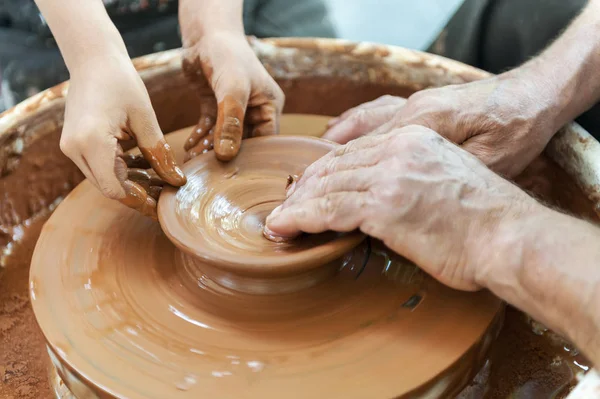 Handcrafted, Hands make clay. Master teaches the student to make