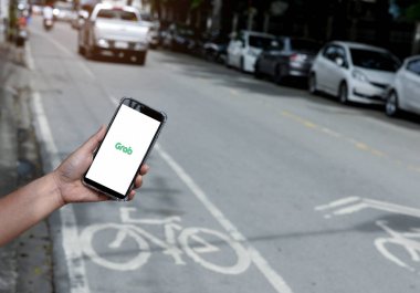 Chiangmai, Tayland - 26 Ağustos 2018. Uygulama akıllı telefon ekranda el bulanık yol arka plan ile kapmak.