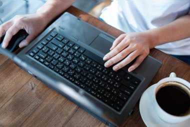 Office kız el laptop klavye ve fare. Masada kahve fincanı.
