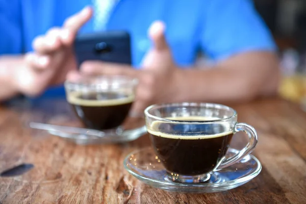 Kaffe Glas Träbord Med Suddig Bakgrund Människor Spela Smart Telefon — Stockfoto