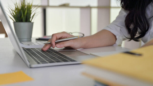 Close - up shot of Hands are working on a laptop keyboard.