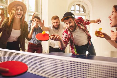 Ping pong Masa Tenisi oynarken mutlu genç arkadaş grubu