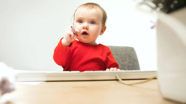 Щаслива дитяча дівчинка малюк сидить з клавіатурою комп'ютера ізольовано на білому тлі — стокове фото