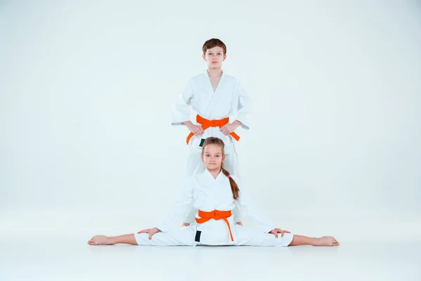 El niño y la niña posando en el entrenamiento Aikido en la escuela de artes marciales. Estilo de vida saludable y concepto deportivo —  Fotos de Stock