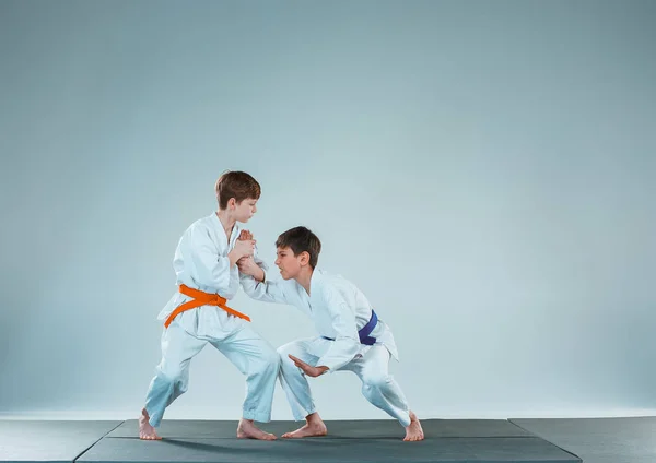 Два мальчика сражаются на тренировках Айкидо в школе боевых искусств. Здоровый образ жизни и спортивная концепция — стоковое фото