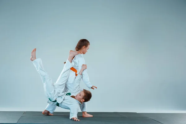 Мальчик, сражающийся на тренировках Айкидо в школе боевых искусств. Здоровый образ жизни и спортивная концепция — стоковое фото