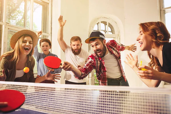 Grupo de jóvenes amigos felices jugando ping pong tenis de mesa —  Fotos de Stock
