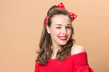 Güzel genç kadın pinup makyaj ve saç modeli ile. Pastel arka plan üzerinde atış stüdyo