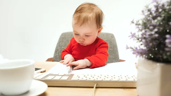 Щаслива дитяча дівчинка малюк сидить з клавіатурою комп'ютера ізольовано на білому тлі — стокове фото