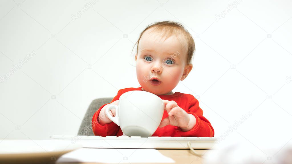 Happy child baby girl toddler sitting with keyboard of computer isolated on a white background