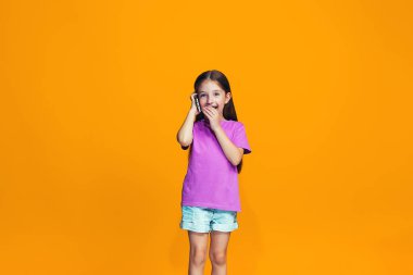 Mutlu genç kız ayakta ve telefon ile gülümseyen
