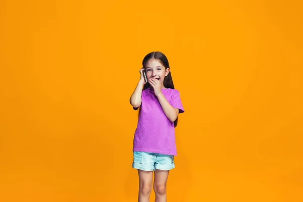 A boldog tini lány állt, és mosolyogva, telefon — Stock Fotó
