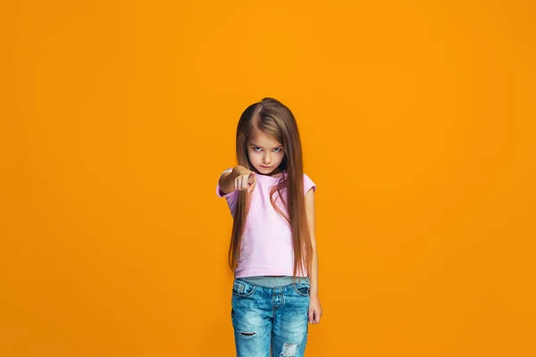 Den glada teen flicka pekar du, halv längd närbild porträtt på orange bakgrund. — Stockfoto