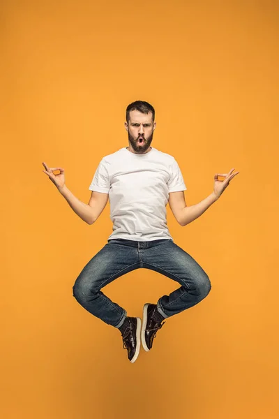 Свобода в русі. красивий молодий чоловік стрибає на помаранчевому фоні — стокове фото