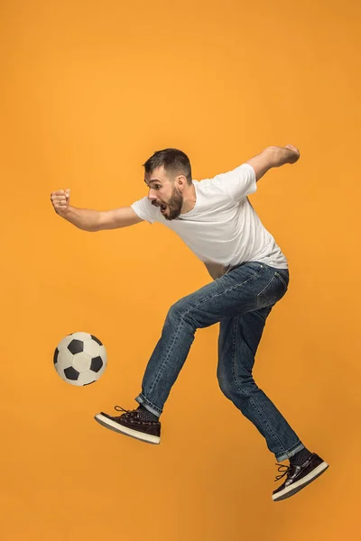 El joven como futbolista pateando la pelota en el estudio — Foto de Stock