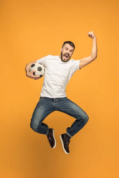 De jonge man als voetbal voetbalspeler de bal schoppen op studio — Stockfoto