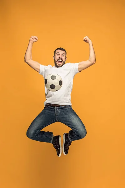 stock image The young man as soccer football player kicking the ball at studio