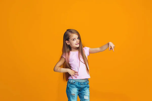 Ευτυχής έφηβος κορίτσι παρουσιάζει κάτι, μισού μήκους closeup πορτραίτο σε πορτοκαλί φόντο. — Φωτογραφία Αρχείου