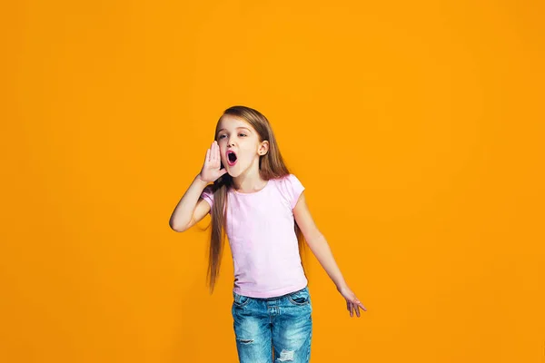 Isolerade på orange casual tonåring flicka skriker på studio — Stockfoto