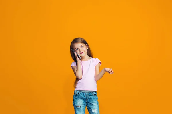 Ευτυχισμένος Κορίτσι Στέκεται Χαμογελώντας Κινητό Τηλέφωνο Μοντέρνα Στούντιο Πορτοκαλί Φόντο — Φωτογραφία Αρχείου