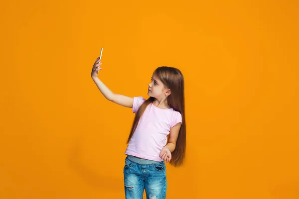 L'adolescente heureuse debout et souriant avec le téléphone — Photo