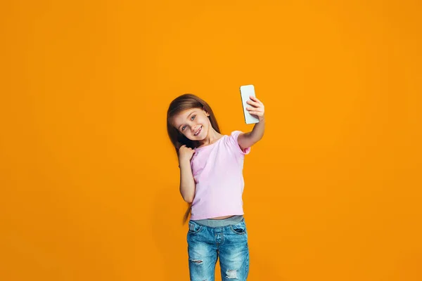 Щаслива дівчина-підліток стоїть і посміхається з телефоном — стокове фото
