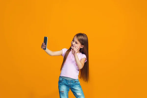 L'adolescente heureuse debout et souriant avec le téléphone — Photo