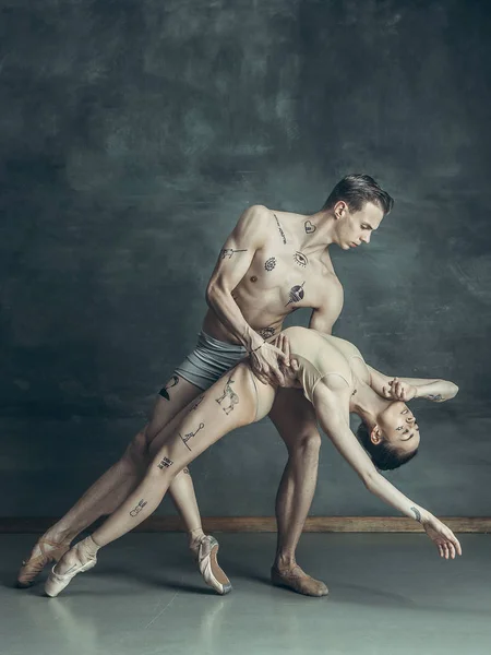 Os jovens bailarinos modernos posando no fundo do estúdio cinza — Fotografia de Stock