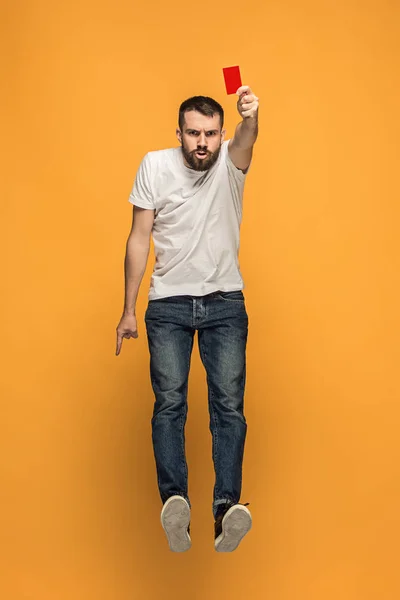 Football supporter with red card on orange background