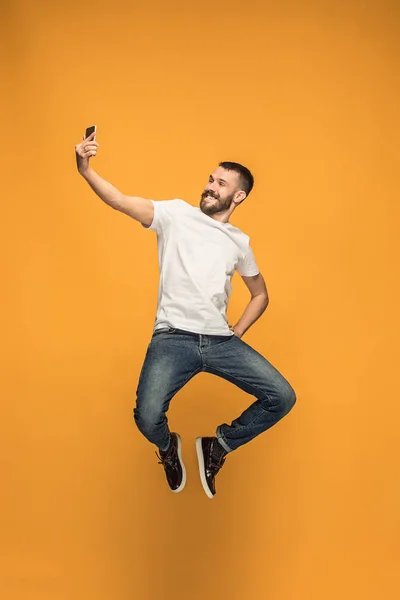 Tijd om te nemen van de selfie. Volledige lengte van de knappe jongeman nemen selfie tijdens het springen — Stockfoto