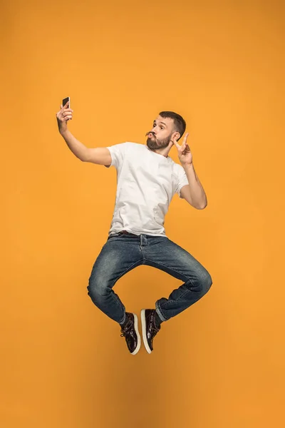 Tijd om te nemen van de selfie. Volledige lengte van de knappe jongeman nemen selfie tijdens het springen — Stockfoto