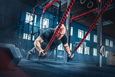 Savaş ip savaş ipleri egzersiz fitness salonunda erkeklerle.