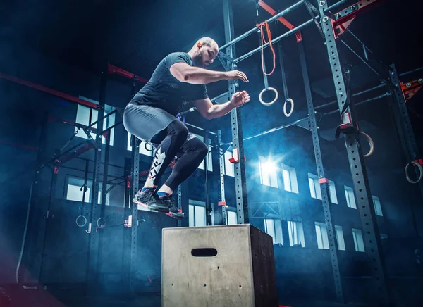 Man springen tijdens de oefeningen in de fitnessruimte. CrossFit. — Stockfoto