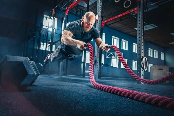 Los hombres con cuerdas de batalla se ejercitan en el gimnasio de fitness . — Foto de Stock