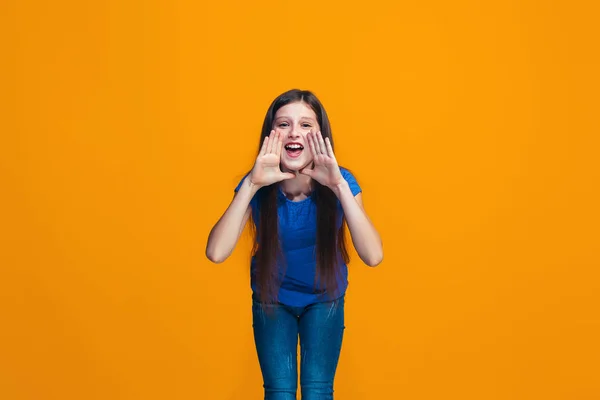 Izolované na žluté mladé casual dospívající dívka křičí na studiu — Stock fotografie