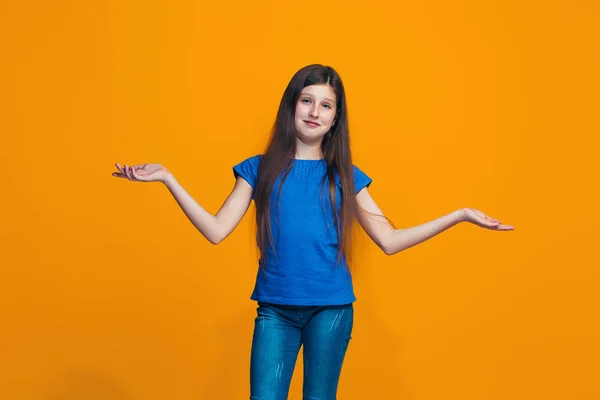 Vackra teen flicka tittar förvånade och förvirrade isolerade på orange — Stockfoto