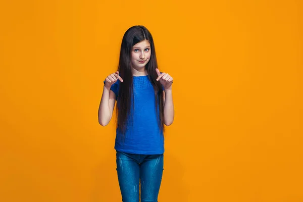 A menina adolescente feliz de pé e sorrindo contra o fundo laranja . — Fotografia de Stock