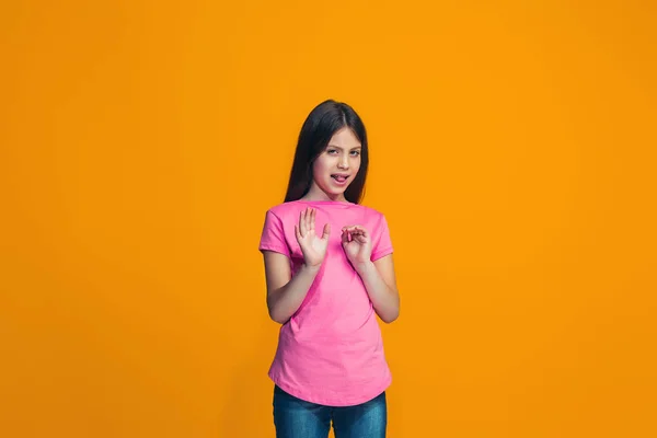 Сумнівна стомлива дівчина-підліток відкидає щось на помаранчевому тлі — стокове фото