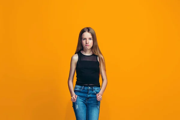 Portret van boze tiener meisje op een oranje studio achtergrond — Stockfoto