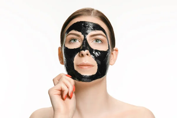 젊고 아름 다운 여자 치료 검은 진흙의 얼굴에 대 한 마스크를 적용. 에스테틱 — 스톡 사진