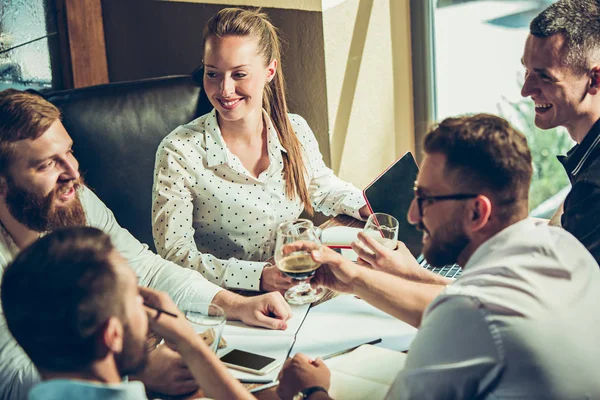 Los jóvenes alegres sonríen y hacen gestos mientras se relajan en el pub . — Foto de Stock