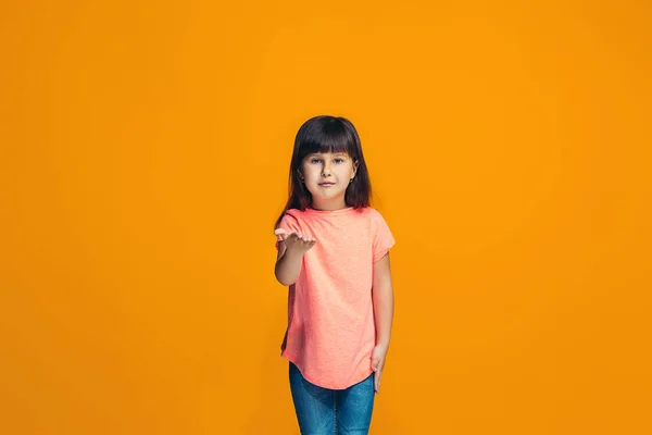 A menina adolescente feliz de pé e sorrindo contra o fundo laranja . — Fotografia de Stock