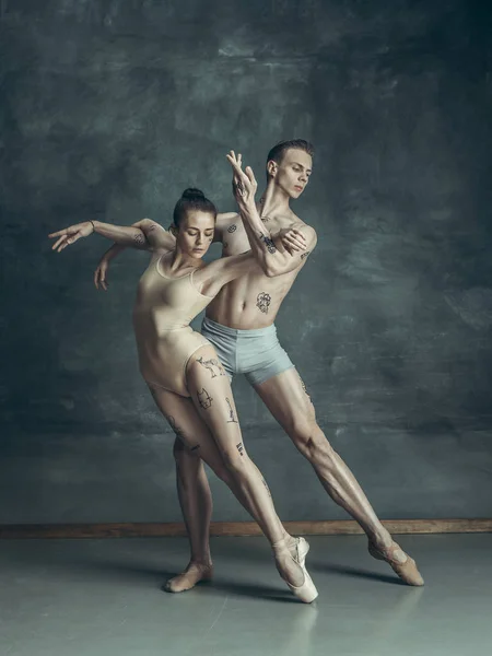 The young modern ballet dancers posing on gray studio background — Stock Photo, Image