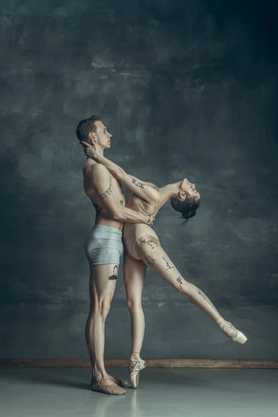 Os jovens bailarinos modernos posando no fundo do estúdio cinza — Fotografia de Stock