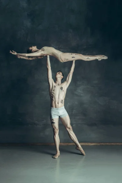 Os jovens bailarinos modernos posando no fundo do estúdio cinza — Fotografia de Stock