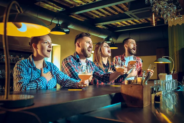 Sport, mensen, vrije tijd, vriendschap en entertainment concept - gelukkig voetbalfans of mannelijke vrienden drinken bier en vieren overwinning bij bar of pub — Stockfoto