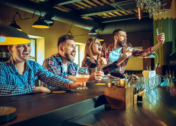 Sport, mensen, vrije tijd, vriendschap en entertainment concept - gelukkig voetbalfans of mannelijke vrienden drinken bier en vieren overwinning bij bar of pub — Stockfoto